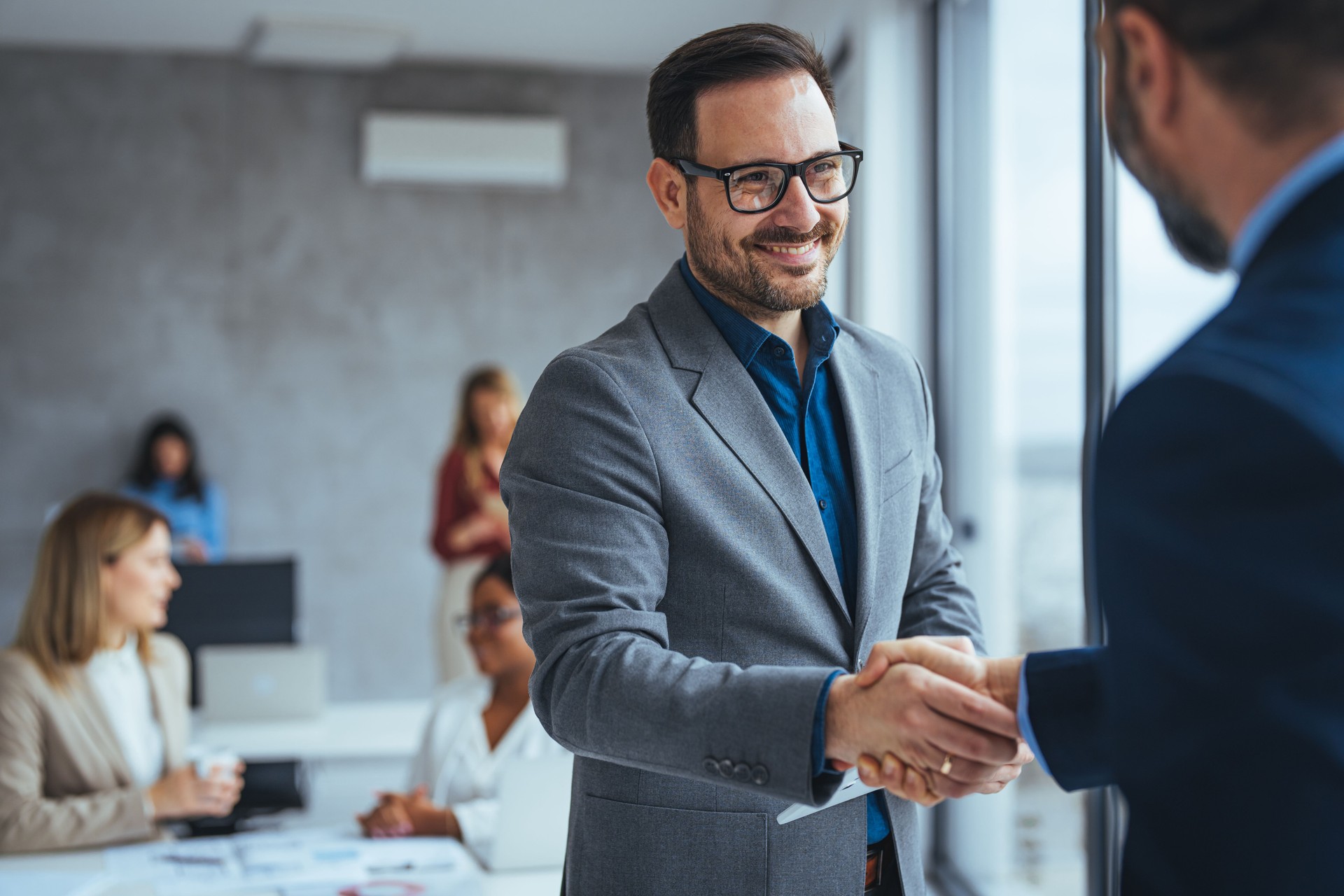 Porträt der fröhliche junge Manager Handshake mit neuer Mitarbeiter.